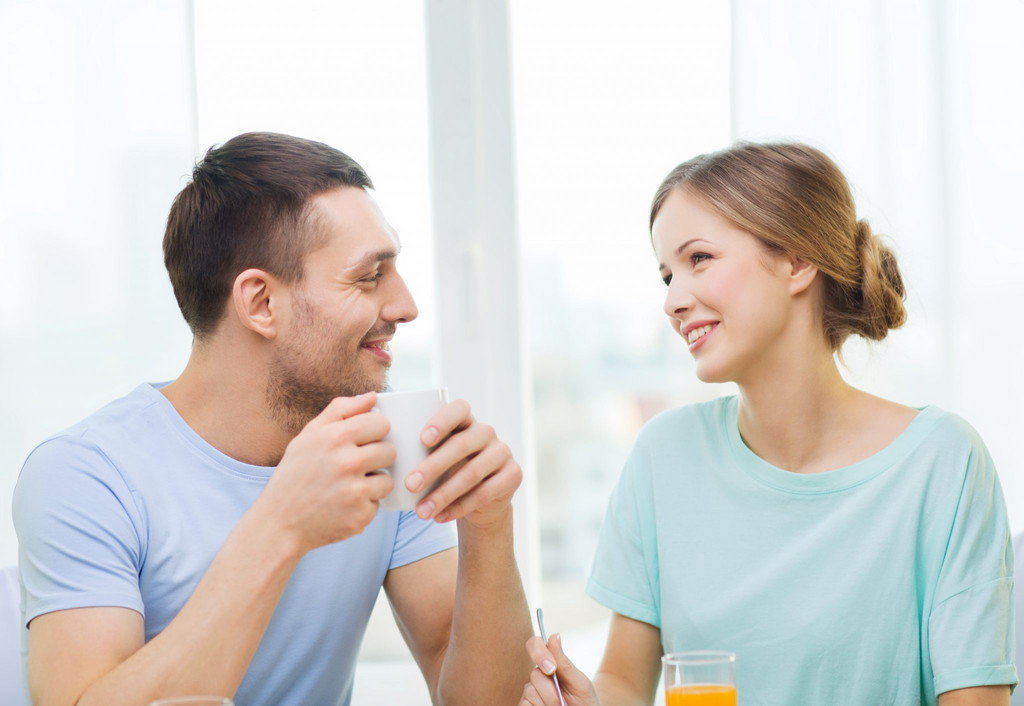説明：男女がテーブルに座り、お互いに英語で会話しています。