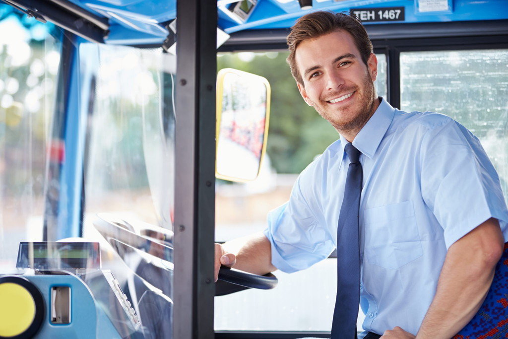 バスの運転席に座って英語で英会話の練習をしている男性。