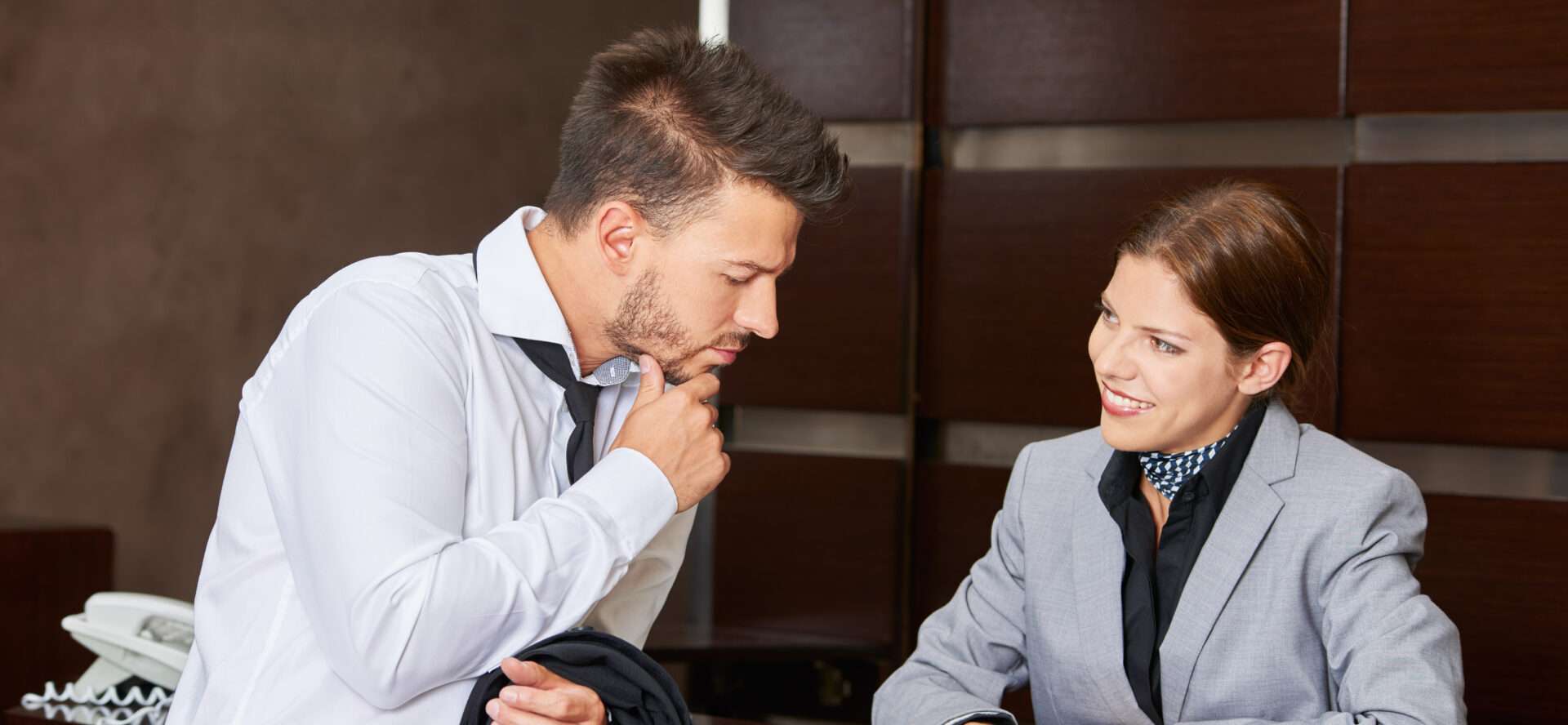 机に座って英語で会話する男性と女性。