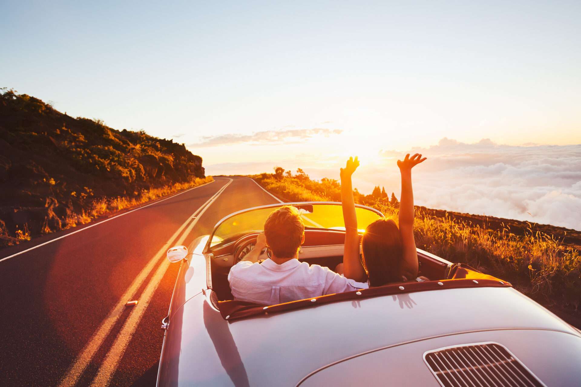 オープンカーでロード旅行中のカップルが英語を話しています。