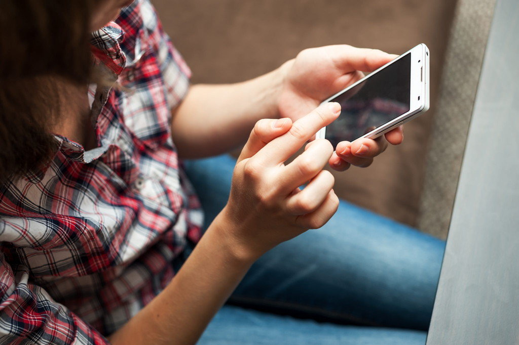 ソファに座り、携帯電話での日本語会話に夢中の女性。