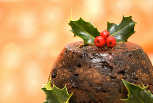 イギリスの伝統的なデザート、クリスマス プディングの上にヒイラギの葉が飾られています。この楽しいおやつはホリデーシーズンの定番で、集まりやお祝いに喜びをもたらします。