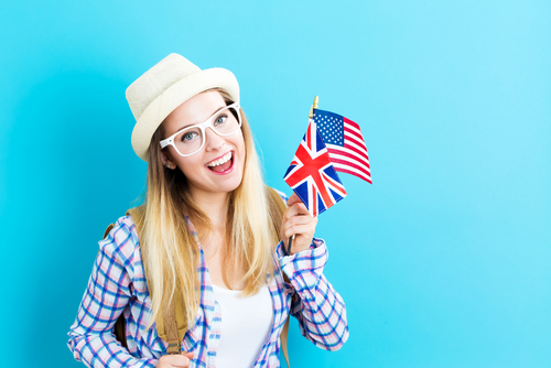 アメリカの国旗を持ち、英会話に取り組む若い女性。