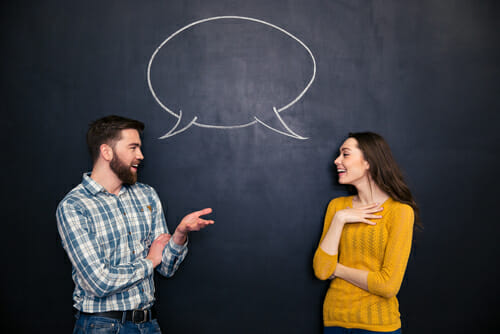 黒板の前で英会話をしながら会話する男女。