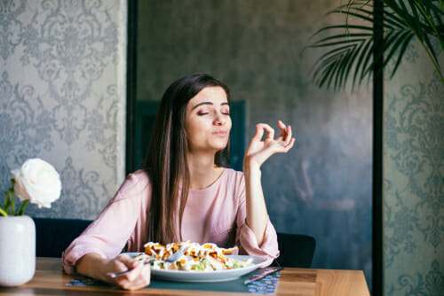 日本語レストランでサラダを食べる若い女性。