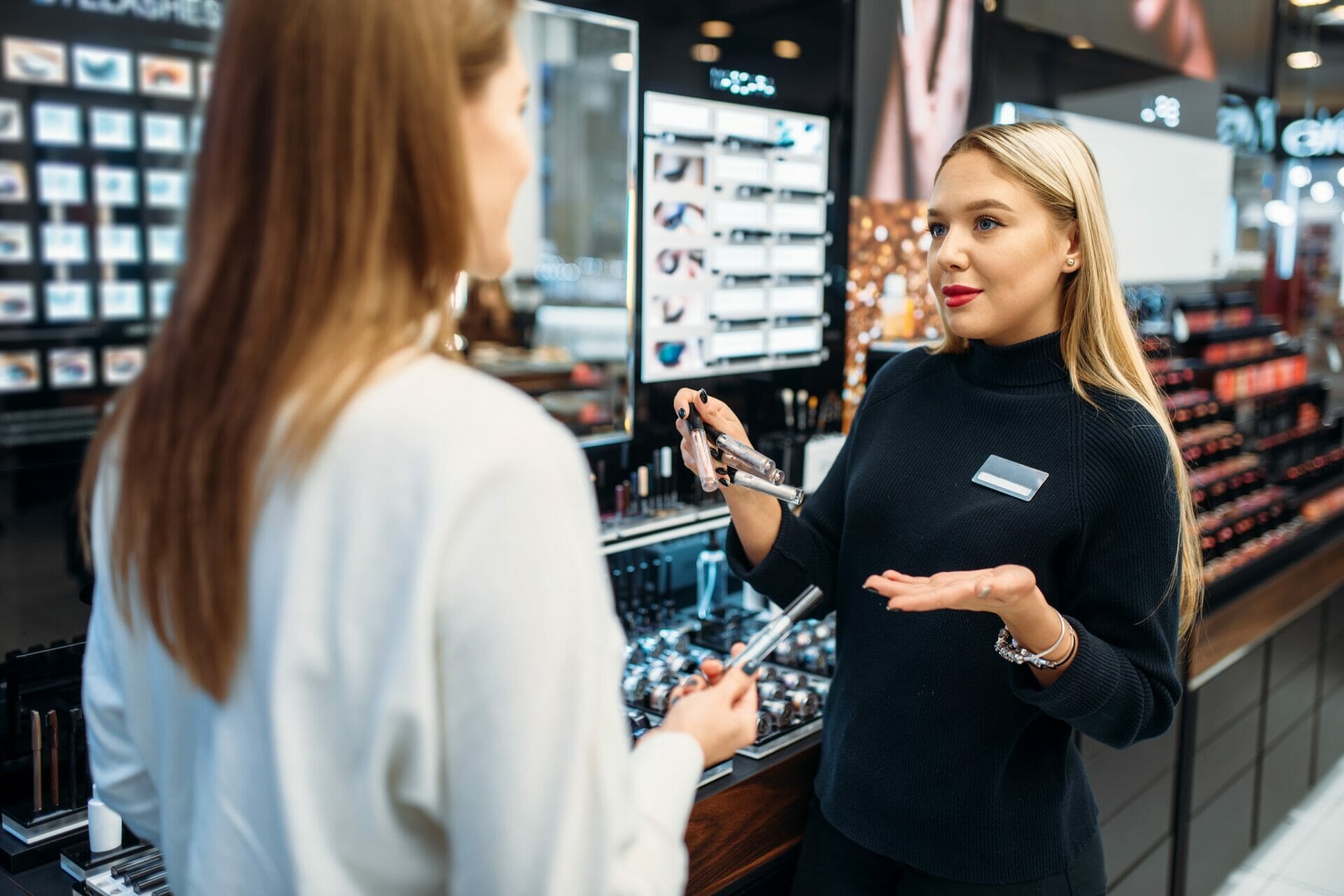 化粧品店で女性が女性に英語で話している。