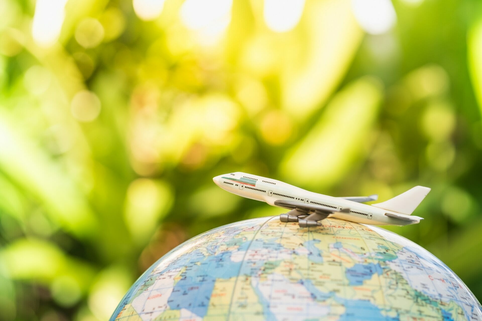 おもちゃの飛行機が地球儀の上に乗っています。
