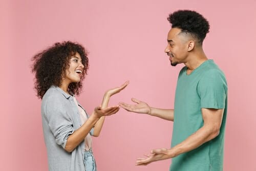 ピンクの背景で会話する男性と女性。