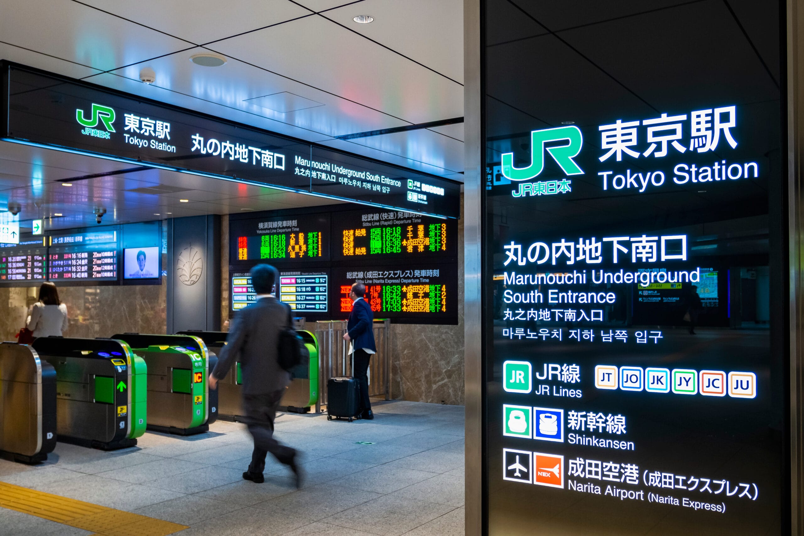 東京駅丸の内地下南口の改札付近を歩いている人々は、電飾看板やデジタルディスプレイに囲まれ、旅行者が移動中に英語を練習する際の英会話マンツーマンのレッスンの断片を耳にすることがあります。.