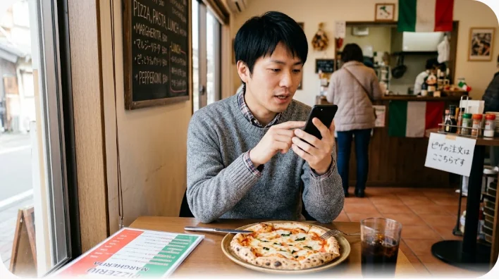 リビングのソファでスマートフォンを耳に当てながらピザを注文する二人の女性