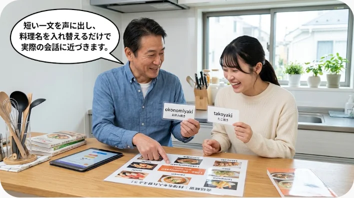英語練習用ノート、スマートフォン、箸、味噌汁、暗記カードが机に置かれている